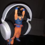 Goku holding a pair of white headphones