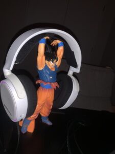 Goku holding a pair of white headphones