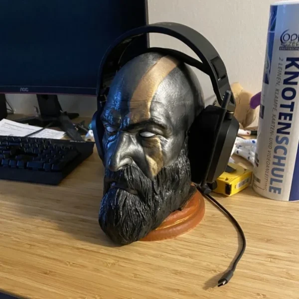 a headphone stand of Kratos God of War with headphones on a desk